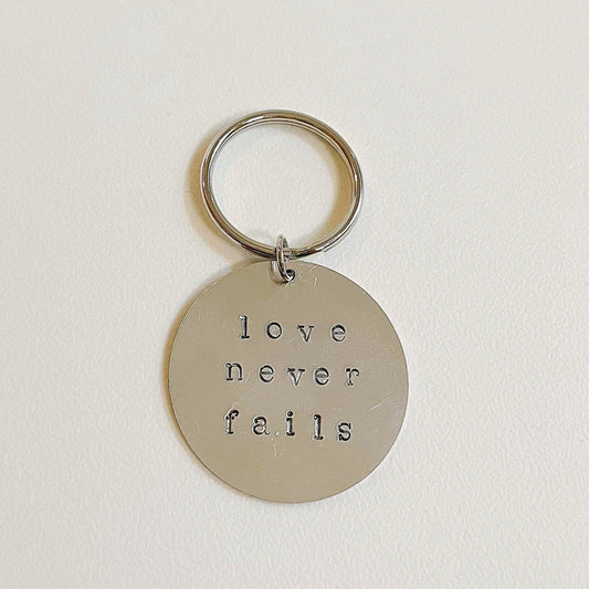 love never fails keychain